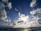 Beach with Gentle Surf under a Sky Filled with Puffy Clouds