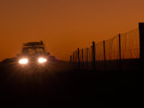 Twilight View of a Vehicle Traveling Next to a Wire Fence That Stretches 3307 Miles