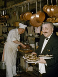 Waiter Holds Plates of Oysters  a Chef Carves a Roast