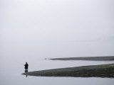 Lone Fisherman Fishing on a Misty Coast