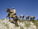 Cowboy Rides Quarter Horse Up Hill of Sand and Scrub  Others Watch