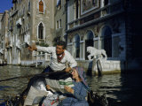 Gondolier Points Out Sights to Passenger with Guidebook in His Boat