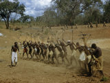 Men Work in Unison Swinging Picks to Build a Catchment Dam