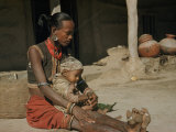 Tharus Woman with Tattoos  Armbands  and Toe Rings Holds an Infant