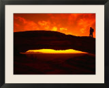 Silhouette of a Hiker on Mesa Arch Against a Spectacular Orange Sky  Utah  USA