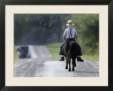 With a Buggy Approaching in the Distance  an Amish Boy Heads Down a Country Road on His Pony