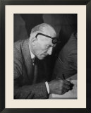 Swiss Architect Le Corbusier Leaning Down to Write with His Glasses Pushed Back on His Forehead