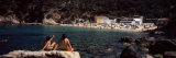 Tourists Sitting on a Rock at the Coast  Aigua Blava  Costa Brava  Catalonia  Spain
