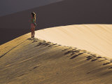 Young Woman Walks across the Dunes at Sunset at Sossusvlei  Namibia