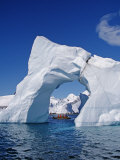 Grandidier Channel  Tourists Zodiac Cruising by Arched Iceberg Near Booth Island  Antarctica