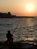 Fisherman Watches as the Sun Goes Down on the Waterfront of Alexandria  Egypt