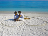 Young Couple on Beach Sitting in a Heart Shaped Imprint on the Sand  Maldives  Indian Ocean  Asia