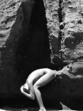 Nude Woman Crouching Between Crevice