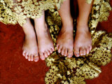 Two Pair of Feet of Small Children with Textile Spread around Them