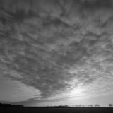 Clouds Obscure the Sun in a Huge Sky with Trees on the Horizon