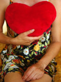 Lady Sitting with Red Cushion Heart Against Her Chest