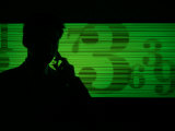 Businessman on a Cell Phone as Stock Quotes Scroll By