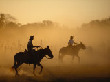 Cowboys Silhouetted in a Glowing Cloud of Dust