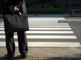 Businessman in a Dark Suit with Briefcase at a Crosswalk