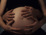 Woman and Her Husband Hold Her Nine Month Pregnant Belly