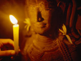 Man Holds a Candle Up to a Stone Carving at the Angkor Wat Temple