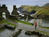 Tourist Walks the Paths of Tintagel Castle Overlooking the Coast