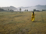 Female Shaman Walks across Grass in a Bright Yellow Silk Robe