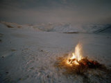 Campfire Burns in a Snow Covered High Altitude Landscape
