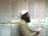 Electoral Worker Passes Election Results Posted on Wall at a Counting Center in Kabul  Afghanistan