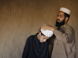Afghan Refugee Teacher Adjusts the Turban for His Student