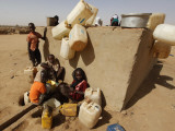 Refugee Children Wait their Turn to Collect Water Supplies at a Water Station in Sudan