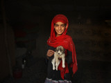 Girl Holds a Puppy as the Sun Sets over Kabul's Impoverished Teppe Maranjan Neighborhood