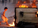 Bahraini Child Plays Near to Burning Tires and a Dumpster