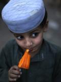 Boy Eats an Ice Lolly in a Neighborhood on the Outskirts of Islamabad  Pakistan