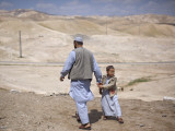 Palestinian Father and Son Walk in Desert During Celebrations Marking the Annual Day of Nebi Musa
