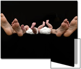 Feet of Caucasian Family  Parents and Twin Babies Against Black Background