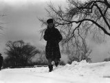 Woman in Winter Clothing Running Through Snow