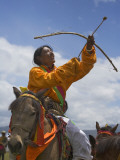 China  Western Sichuan Province  Litang  Tibetan Man Performing Archery on Horseback at Horse Race
