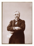 Gustave Eiffel debout tenant un crayon et un rouleau de papier