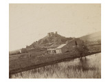 Vue d'une colline portant une forteresse médiévale avec des marais au premier plan