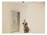 Femme lisant dans une cour aux murs blancs