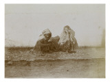 Two Men Leaning Against a Wall in a Street of Biskra
