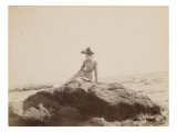 Jeune femme assise sur un rocher  au bord de la mer