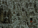 Serene Stone Faces Smile on Two Robed Monks Who Peer from Temple