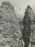 A Rock Climber Bridges a Gap Between Towering Peaks