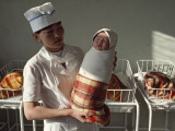 A Nurse Holds a Tightly Wrapped Newborn Baby