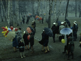People Strolling Through a Park During a Wet May Snowstorm