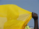 Back to the Camera  a Person Holds Up a Yellow Piece of Fabric