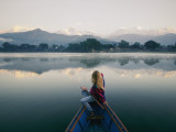 A Woman in a Rowboat Gazes at the Annapurna Range at Dawn