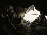 A Woman Kneels to Pray to Buddha in Sacred Cave High Above the Mekong